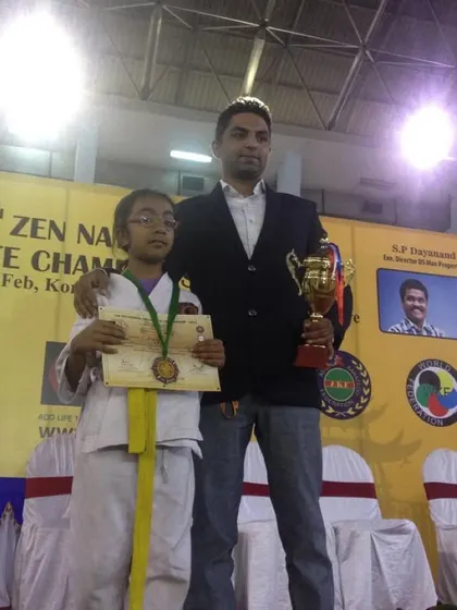A proud moment with one of my students at the 3rd Zen National Karate Championship, holding her medal and the trophy she earned.