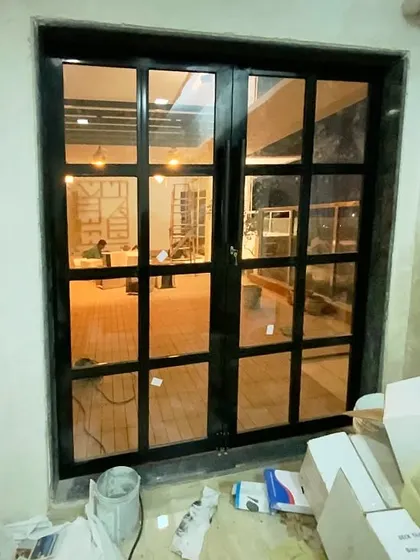 The entrance to your personal paradise. This custom-designed French door now leads to the revamped terrace in Belapur, creating a beautiful transition from the indoor living area to the outdoor lounge.