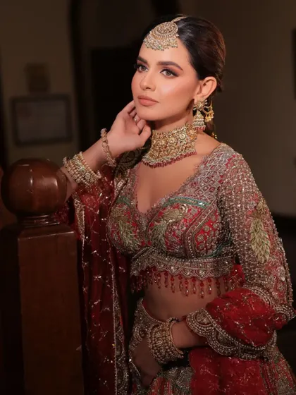 A regal pose showcasing the full splendor of the bridal jewelry, from the maang tikka to the heavy earrings and choker.