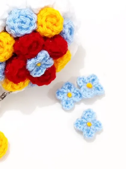 A special Snow White themed mini bouquet keychain, using her signature colors of red, yellow, and blue.