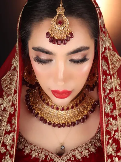 A top-down shot of my international bride, highlighting the detailed eye makeup and the rich red lip. This is a classic combination for a traditional Indian bridal look.