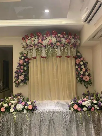 A beautiful floral backdrop with a mix of pastel-colored flowers. The lace-covered base adds a touch of vintage charm to this elegant setup.