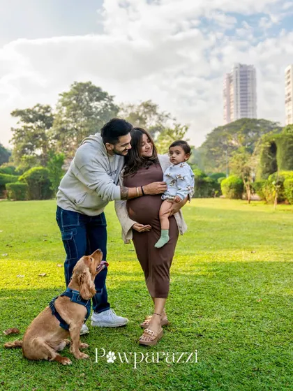 A classic family portrait from an outdoor maternity session. The family stands together with their Cocker Spaniel, creating a timeless image of this special time in their lives.