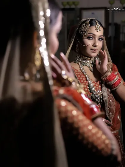 A creative shot using a mirror to capture the bride's reflection. This adds depth and an artistic touch to the portrait, showing her admiring her final bridal look.