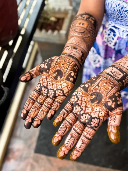 A close-up of the naming ceremony mehendi, showing the "It's me Mom" inscription and other baby-themed details.