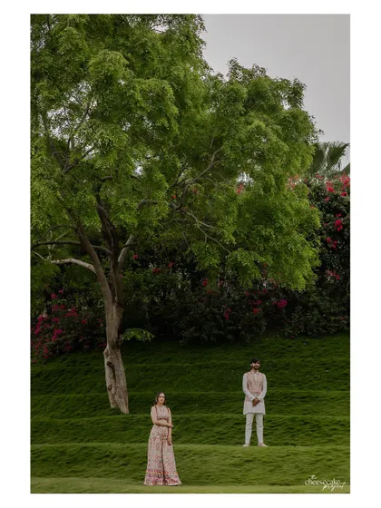 Another perspective of the couple on the green hills, emphasizing the scale of the landscape.