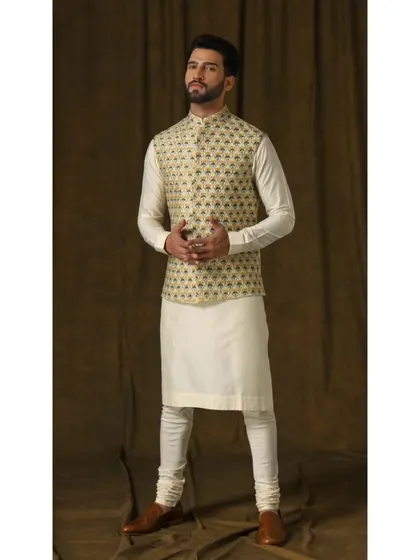 A vibrant lemon-hued Bandi jacket with intricate floral embroidery. Paired with a simple ivory kurta and churidar, this ensemble is designed to bring a fresh and energetic feel to festive daytime events.