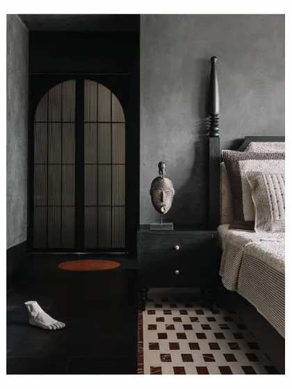 Another angle of the 'Aria' master bedroom, showing the relationship between the four-poster bed, the custom bedside table, and the sculptural decor. The dark, moody tones and natural textures create a deeply personal and restful atmosphere.