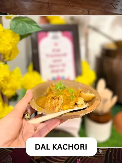 A guest holds a serving of our Dal Kachori. This savory pastry is filled with a spiced lentil mixture, offering a delicious bite of authentic Indian flavor.