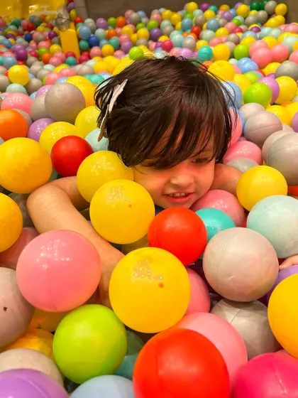 A close-up of pure happiness! Buried in a sea of colorful balls is one of the best parts of visiting Kaboom.