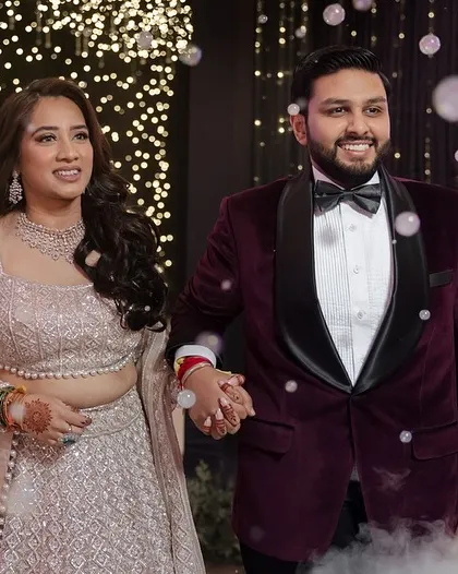 The couple's grand entrance to their Sangeet, surrounded by bubbles and a backdrop of twinkling lights.