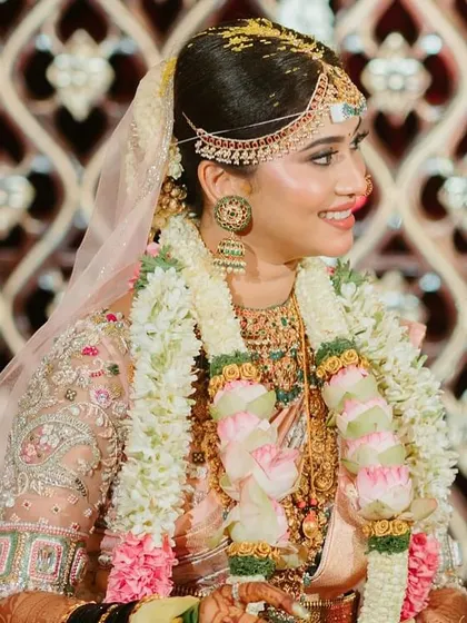 A candid moment of the bride during her wedding ceremony. Her pastel saree and custom-designed blouse create a look of modern sophistication.