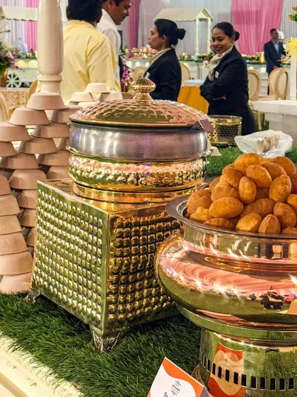 A closer look at our chaat counter setup. The combination of rustic grass, traditional copper and brass vessels, and neatly stacked bowls creates an authentic and inviting atmosphere.