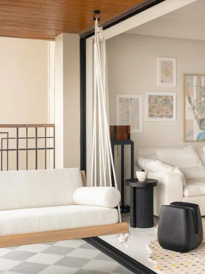 A swing seat offers a playful spot to relax by the window, connecting the indoor living space with the view outside.