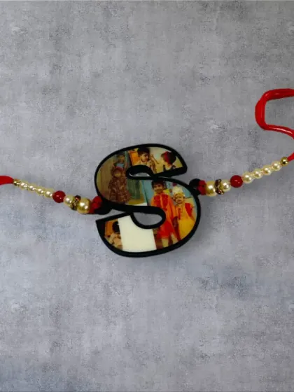 A unique rakhi where the photo is printed within the shape of an initial, in this case, the letter 'S'.