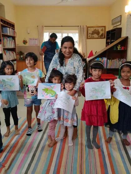 A moment of pure pride and happiness. After an adventurous story about a ghariyal, our members proudly display the colorful drawings they made, surrounded by friends and our supportive storyteller.