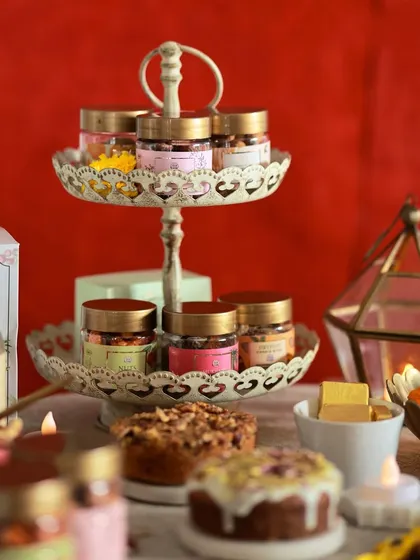 A festive table spread featuring our diverse array of Diwali edibles. From mini tea cakes to jars of flavored nuts, we have a treat for every palate.