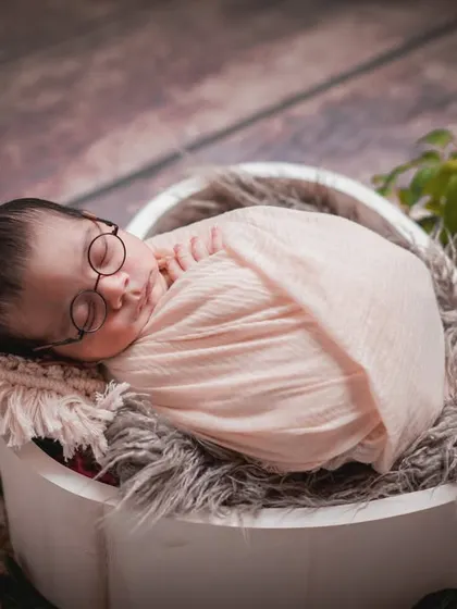 A peaceful scholar at rest. This setup combines a classic basket pose with the whimsical touch of tiny glasses for a memorable portrait.