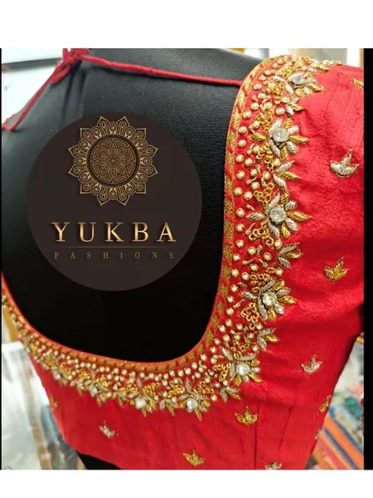 A beautiful red bridal blouse featuring delicate floral embroidery with pearl and stone accents. The deep U-neck is a classic choice for brides looking for an elegant and timeless design.
