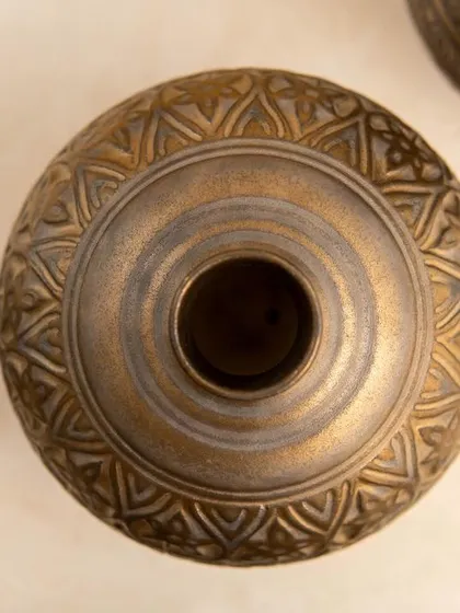 A top down view of a vase glazed with Medieval Gold. This perspective shows how the glaze evenly coats the form while still allowing for beautiful variations in tone.