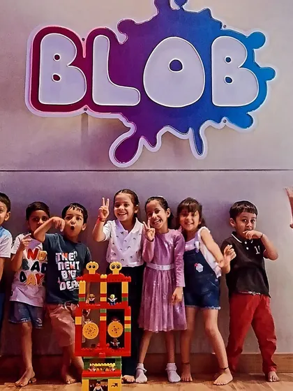 A happy group of campers posing in front of the "Blob" sign at our partner location in Kolkata.