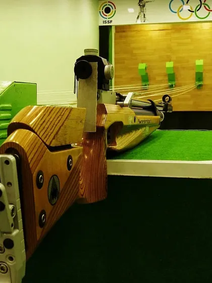 A close-up of a Feinwerkbau air rifle resting on the lane. We believe in training with world-class equipment to give our shooters the best possible advantage.