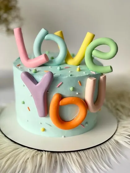 A fun and colorful "LOVE YOU" cake. The playful, 3D letters in pastel colors make this a cheerful and modern way to celebrate your love.