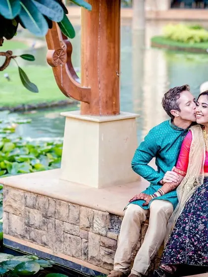 A beautiful portrait by a lily pond. This shot captures a sweet kiss on the cheek in a serene, natural setting.