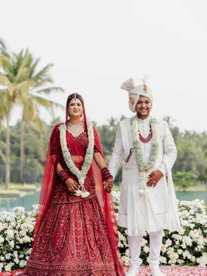 A classic portrait of the couple at their Alila Diwa Goa wedding. The lush greenery and water body provided a stunning natural backdrop.