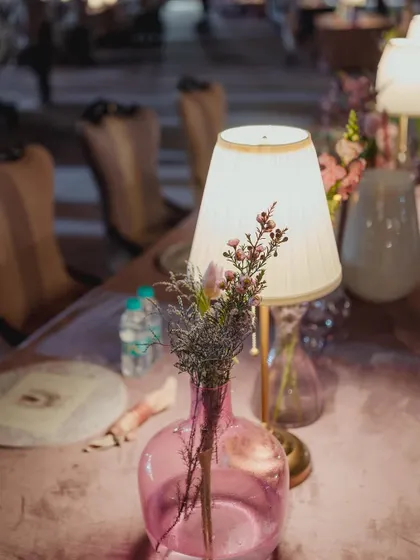 Another view of the exquisite table decorations, with pink glass vases and soft lighting creating a romantic mood.
