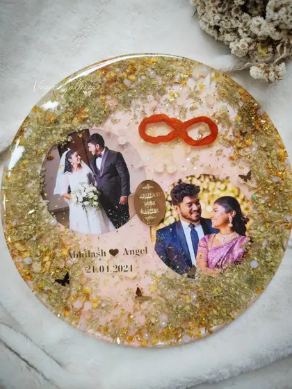A beautiful reminder of vows exchanged. This elegant round frame was created with wedding pictures and elements from a wedding card, with butterflies and glitter for extra charm.