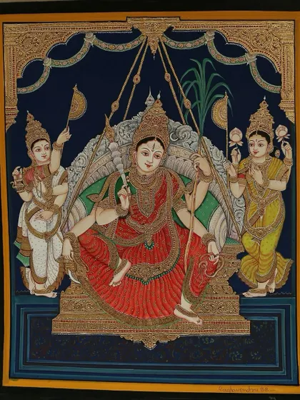 This stunning painting of Goddess Rajarajeshwari seated with Lakshmi Devi and Saraswathi Devi radiates elegance with its intricate work of pure gold leaves.