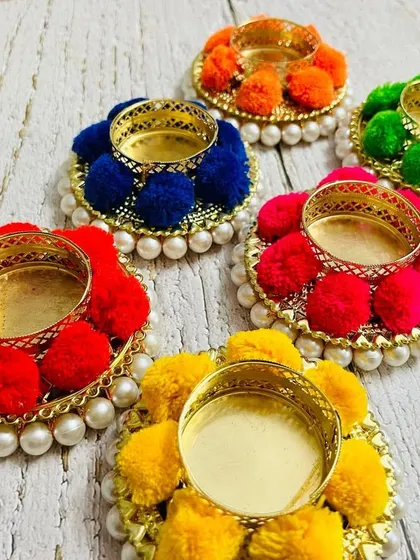 Another view of the assorted pom-pom tea light holders, perfect for adding a pop of color to your festive decor.