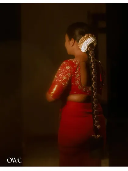 A beautiful shot focusing on the back of the bride's blouse and her intricate hairstyle.