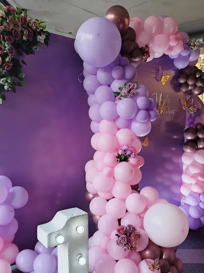 A detailed shot of the organic balloon garland with floral and butterfly accents from the purple-themed party.