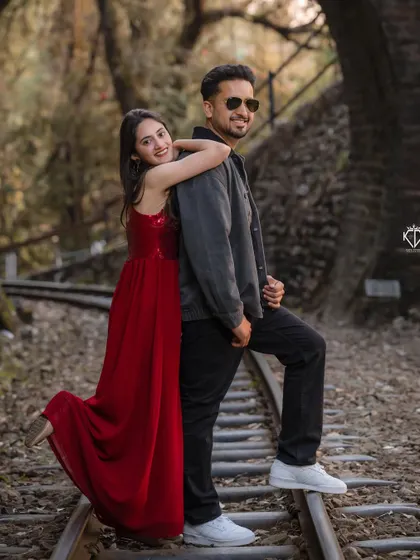 Another angle of a playful pose on the tracks, showcasing the couple's fun-loving dynamic and stylish outfits.