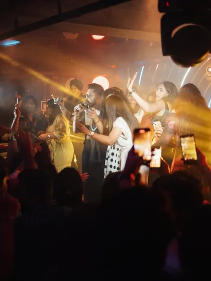 Mika Singh interacting with the crowd, who are all capturing the moment on their phones. This candid shot perfectly encapsulates the energy of a live performance.