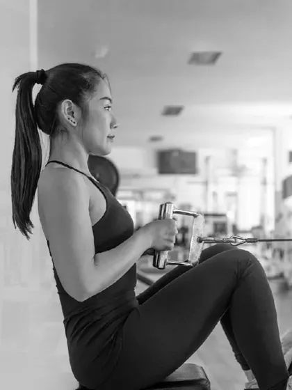 A woman maintains perfect posture while performing a seated cable row, an essential exercise for a strong back.