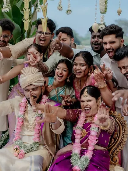 The fun and games of wedding rituals. This moment of laughter during a post-wedding game shows the playful spirit and strong bond between the couple and their families.