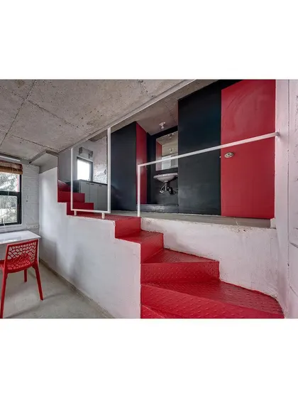 The folded red steel plate staircase is a central feature in each student housing unit. It provides access to the loft and bathroom while also serving as a vibrant, sculptural element that injects color and character into the space.