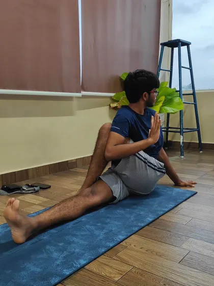 A student performs Ardha Matsyendrasana, a seated spinal twist. This pose is excellent for improving spinal mobility and aiding digestion.
