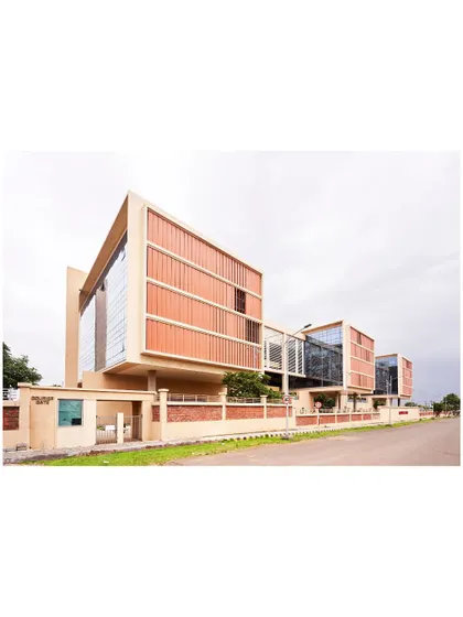 The exterior of the JSW Administrative Office, showcasing the use of brick jaali screens and terracotta-colored fins. These elements are crafted to provide self-shading, reducing thermal gain in response to the local climate.