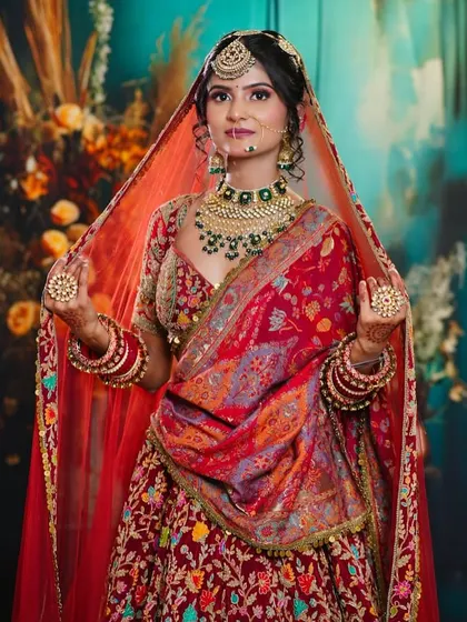 This student's work on a heavily embroidered red lehenga shows their ability to create a look that is both grand and elegant, without overpowering the bride.