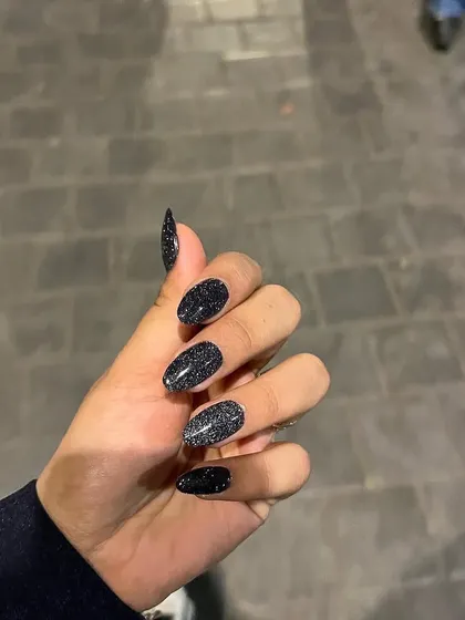A still shot of the reflective black glitter nails. Even without a flash, the deep, multi-dimensional sparkle gives this set a sophisticated and edgy look.