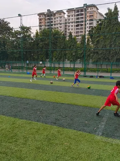 A young boy runs with the ball, showing the energy and passion we encourage in every session.