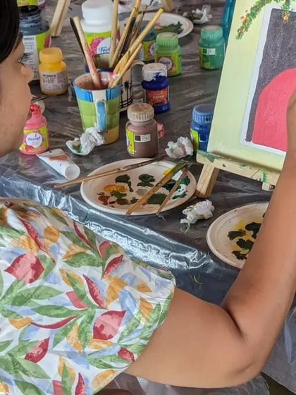 A close-up of a participant painting a floral door, showing the concentration and enjoyment of the process.