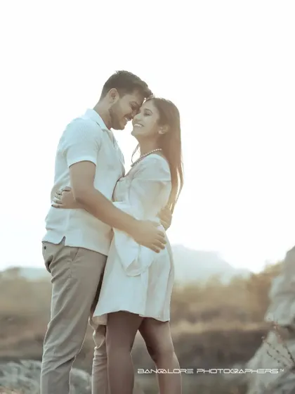 A sun-drenched pre-wedding portrait. The bright light and the couple's happy, loving expressions create a warm and joyful image.