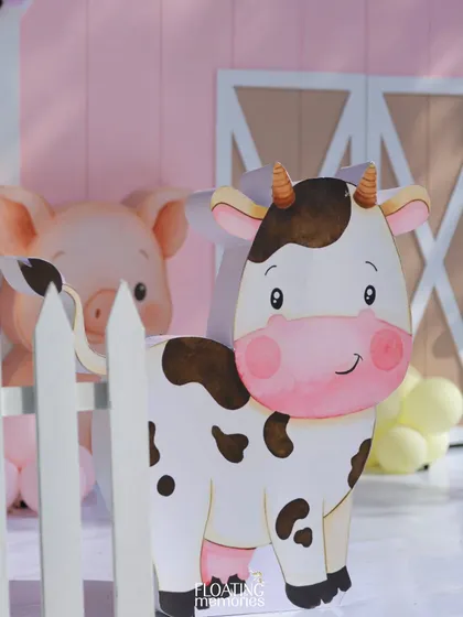 A close-up of the adorable cow cutout, one of the many friendly faces at our pastel barnyard party. The high-quality, custom illustrations are a signature of our themed children's events.