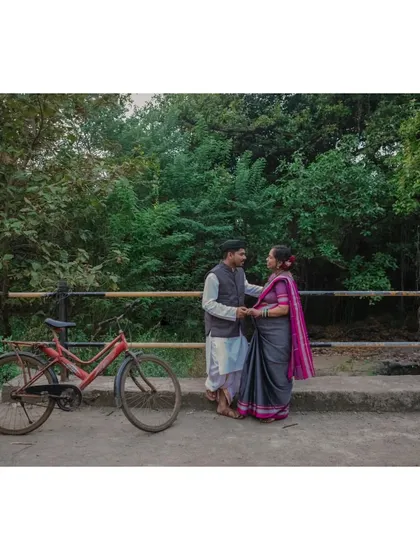 A classic romantic pose by a rustic bridge. The couple's traditional outfits and the old bicycle create a scene straight out of a classic film.