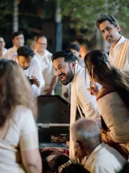 A candid moment of the groom interacting with guests during the wedding ceremony.